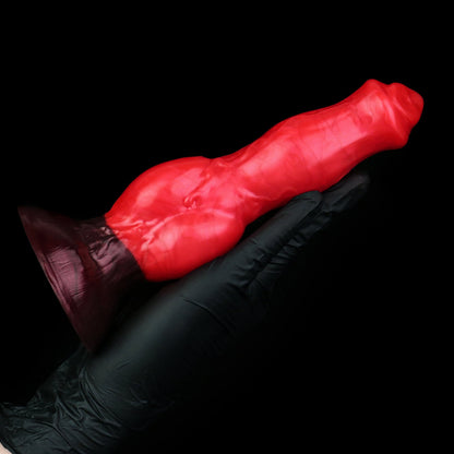 Darkhound the Canine Alpha dildo, Furnace colorway, held in a gloved hand, side view showing the full length