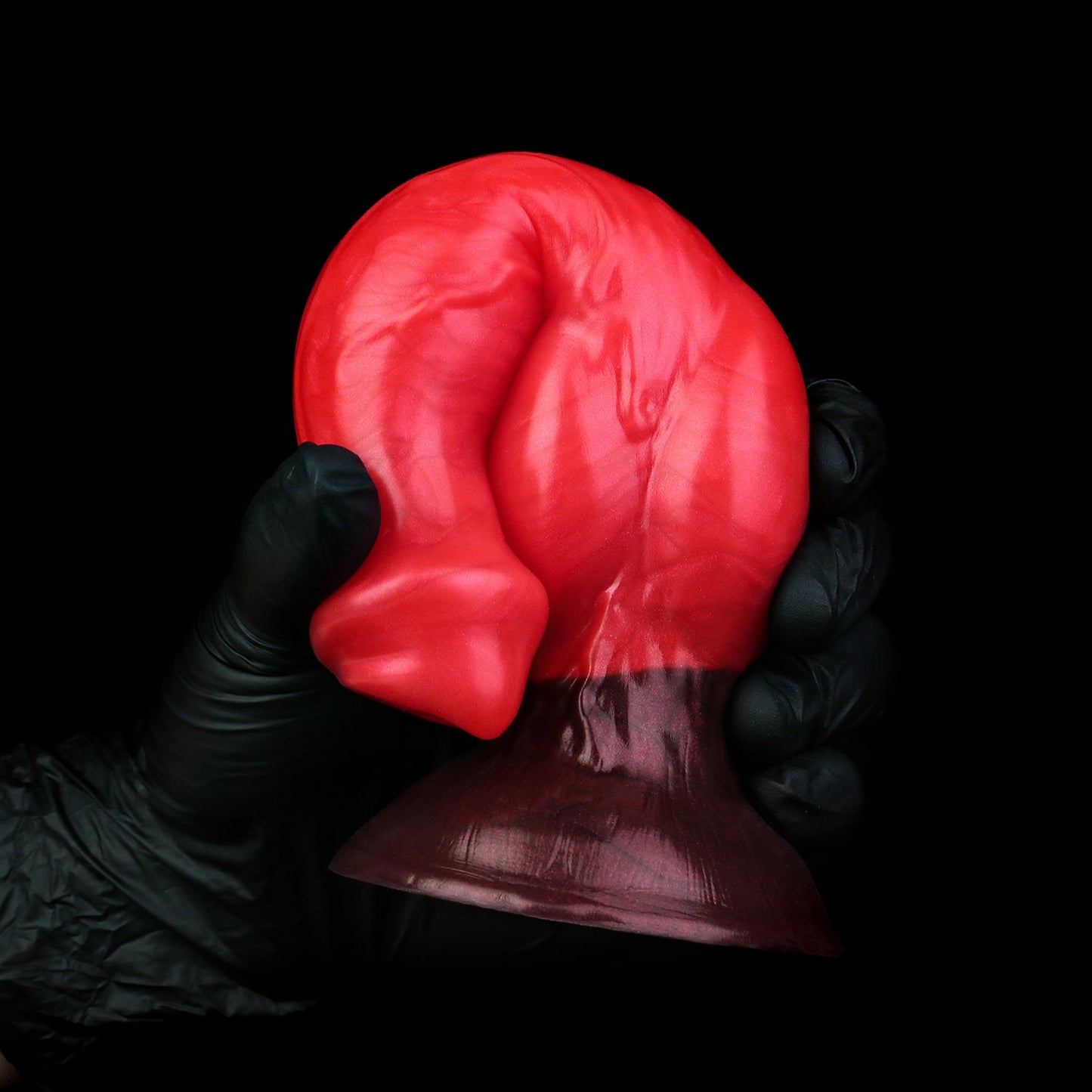 Darkhound the Canine Alpha dildo, Furnace colorway, gloved hand gripping the pronounced canine knot