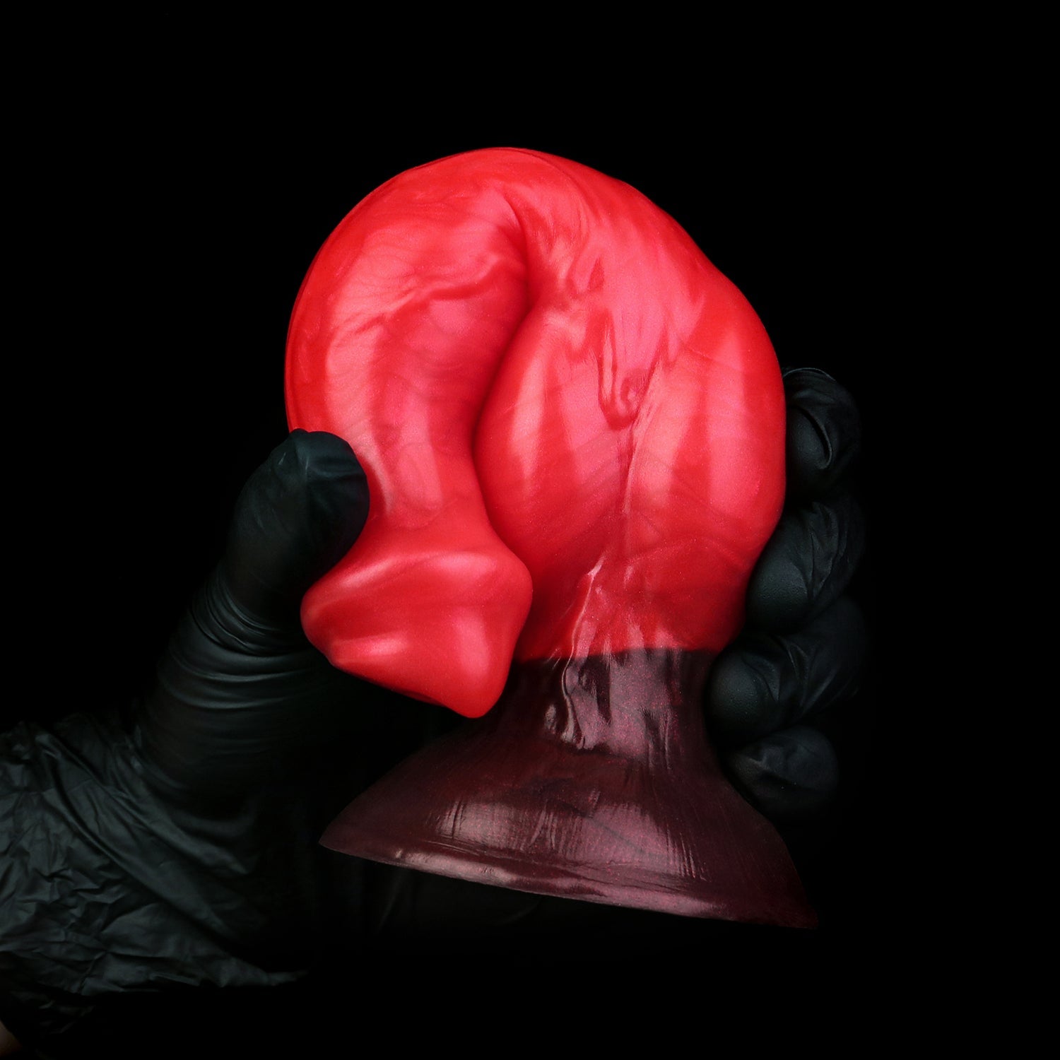 Darkhound the Canine Alpha dildo, Furnace colorway, gloved hand gripping the pronounced canine knot