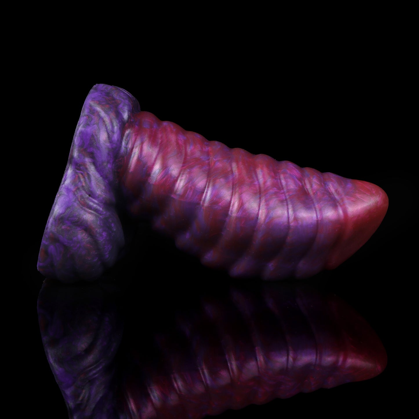 Kael the Dragonkin dildo, Adrenaline colorway, lying on its side in full profile showing the ribbed shaft and scale-textured base