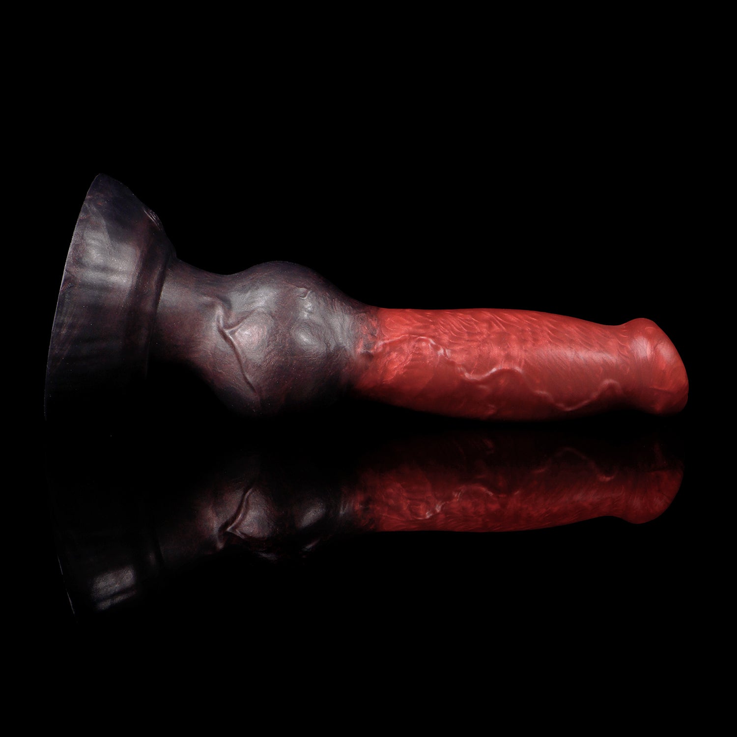 Koda the Guardian dildo, Dusk colorway, lying on its side showing the vivid red head fading through deep maroon into black