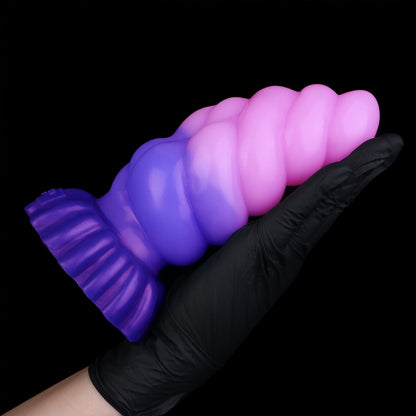Larval the Alien Spawn dildo, Flux colorway, held horizontally in a gloved hand showing the full length