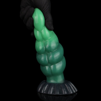 Larval the Alien Spawn dildo, Ogre colorway, held upright by the tip in a gloved hand