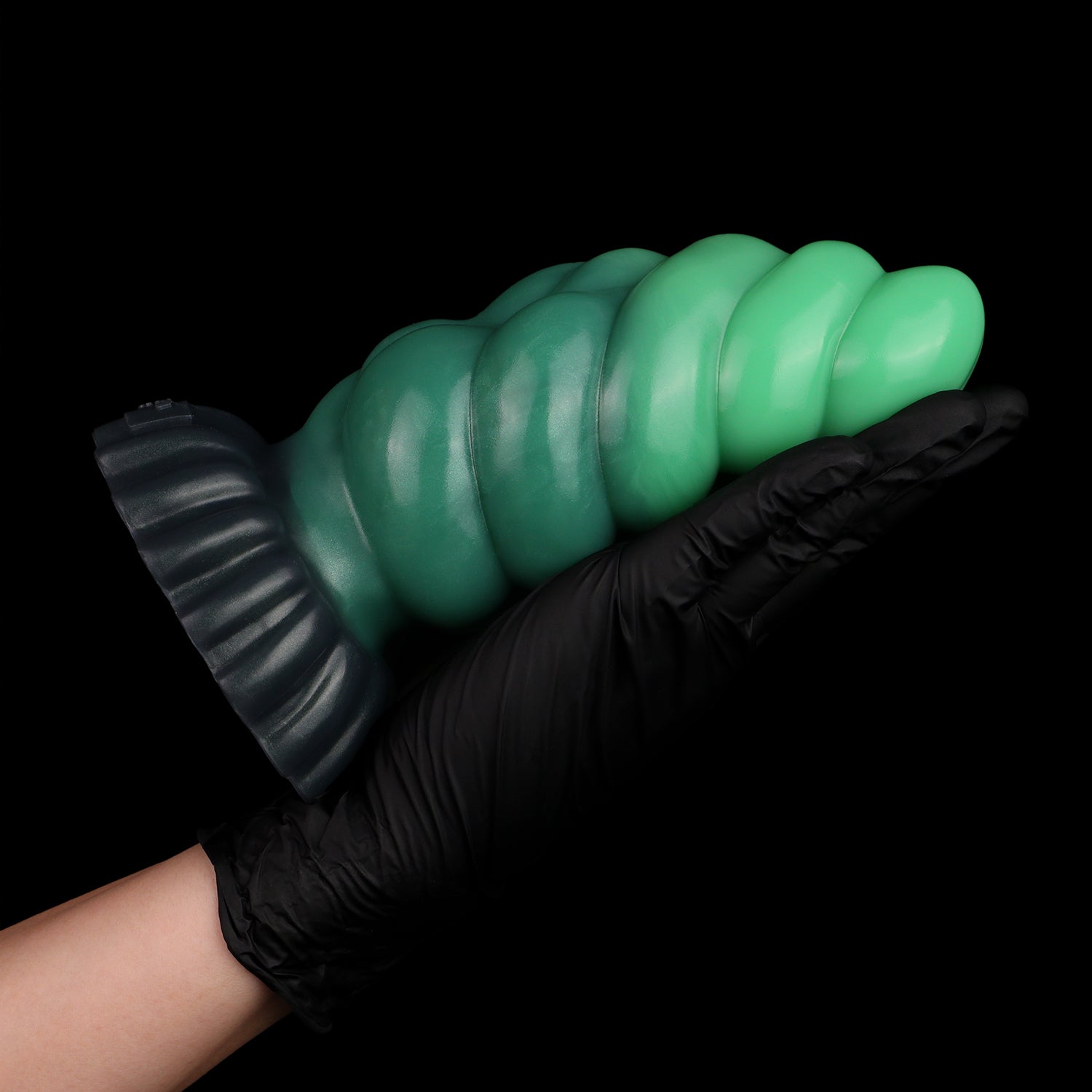 Larval the Alien Spawn dildo, Ogre colorway, held horizontally in a gloved hand showing the full length