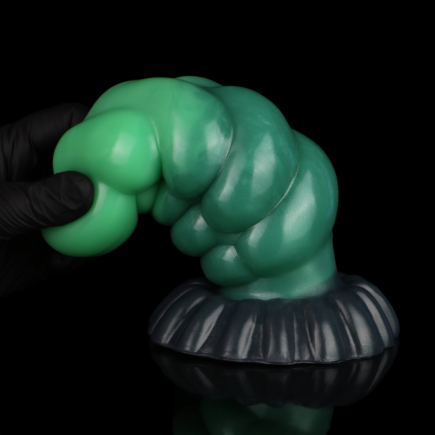 Larval the Alien Spawn dildo, Ogre colorway, gloved hand gripping the tapered green tip