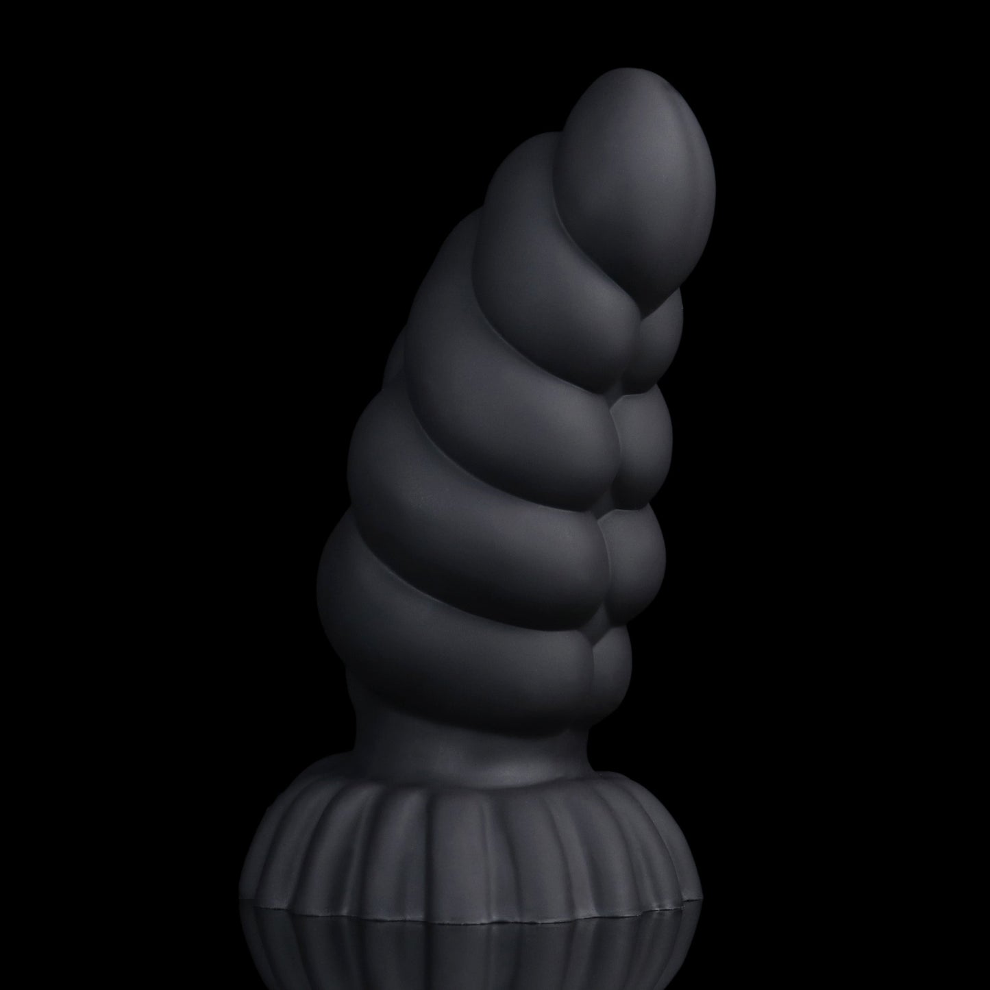 Larval the Alien Spawn dildo, Shadow colorway, standing upright with the curve turned to show the segment ridges