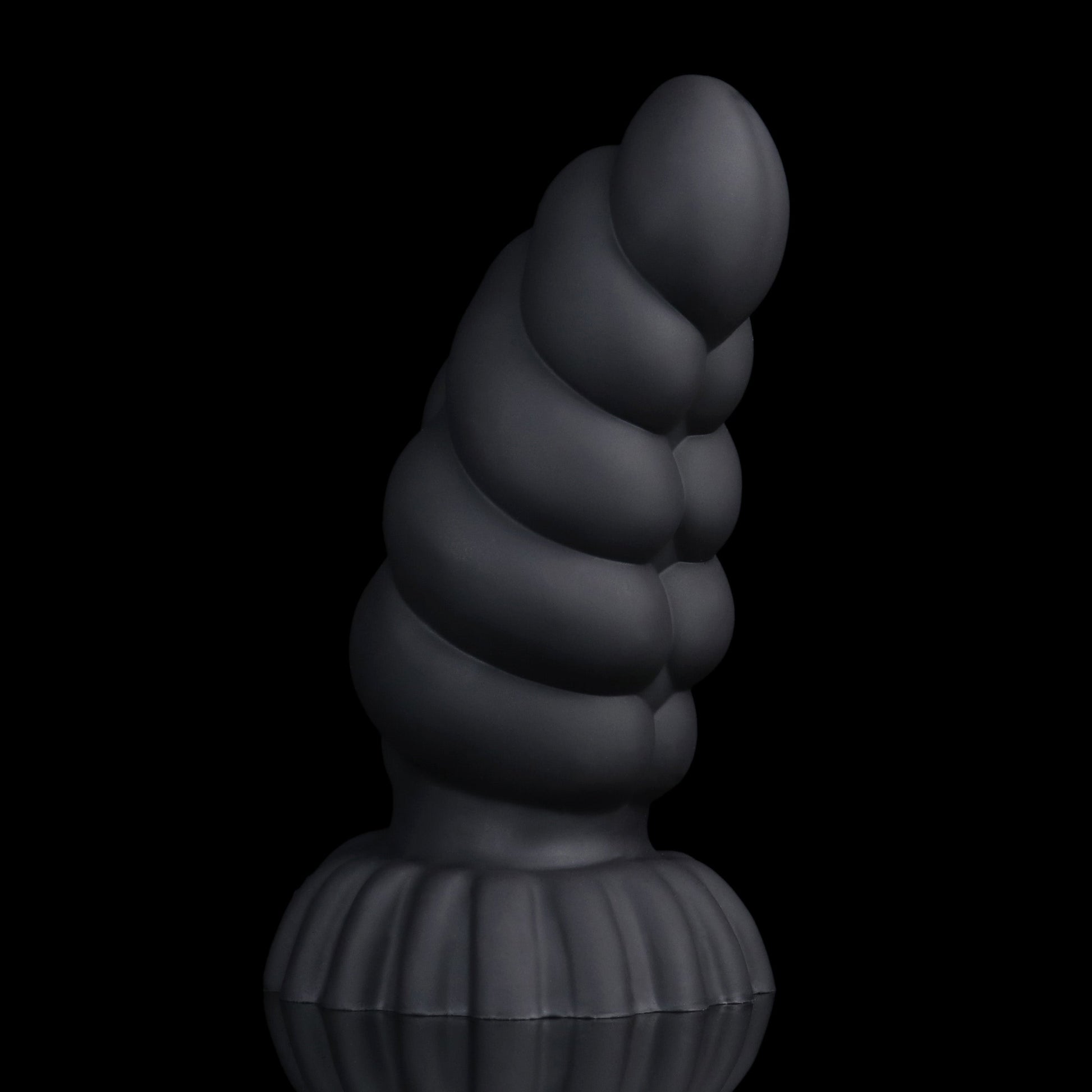 Larval the Alien Spawn dildo, Shadow colorway, standing upright with the curve turned to show the segment ridges