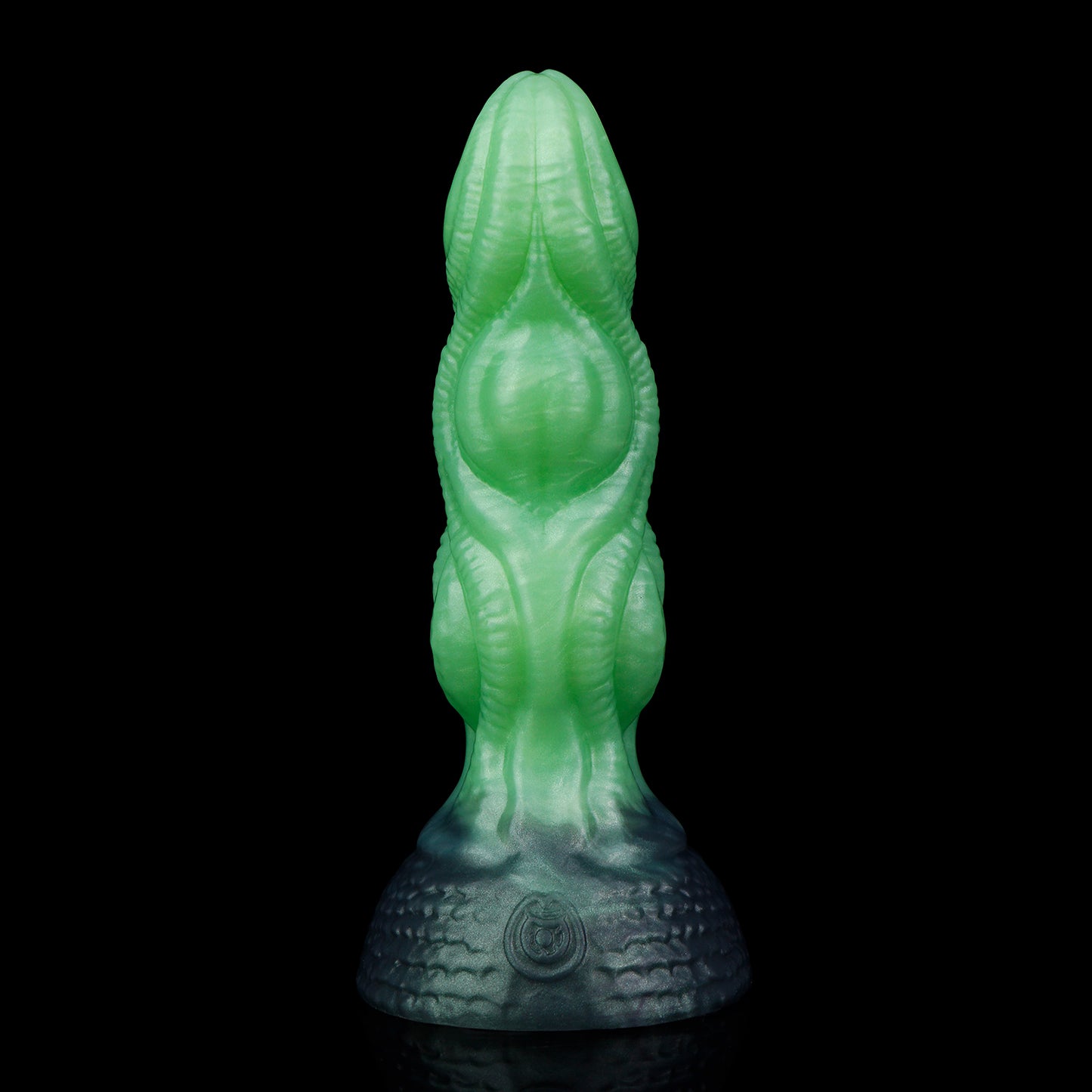 Lumen the Bloomborn dildo, Venom colorway, standing upright showing the luminous green shaft darkening into deep teal-black at the base