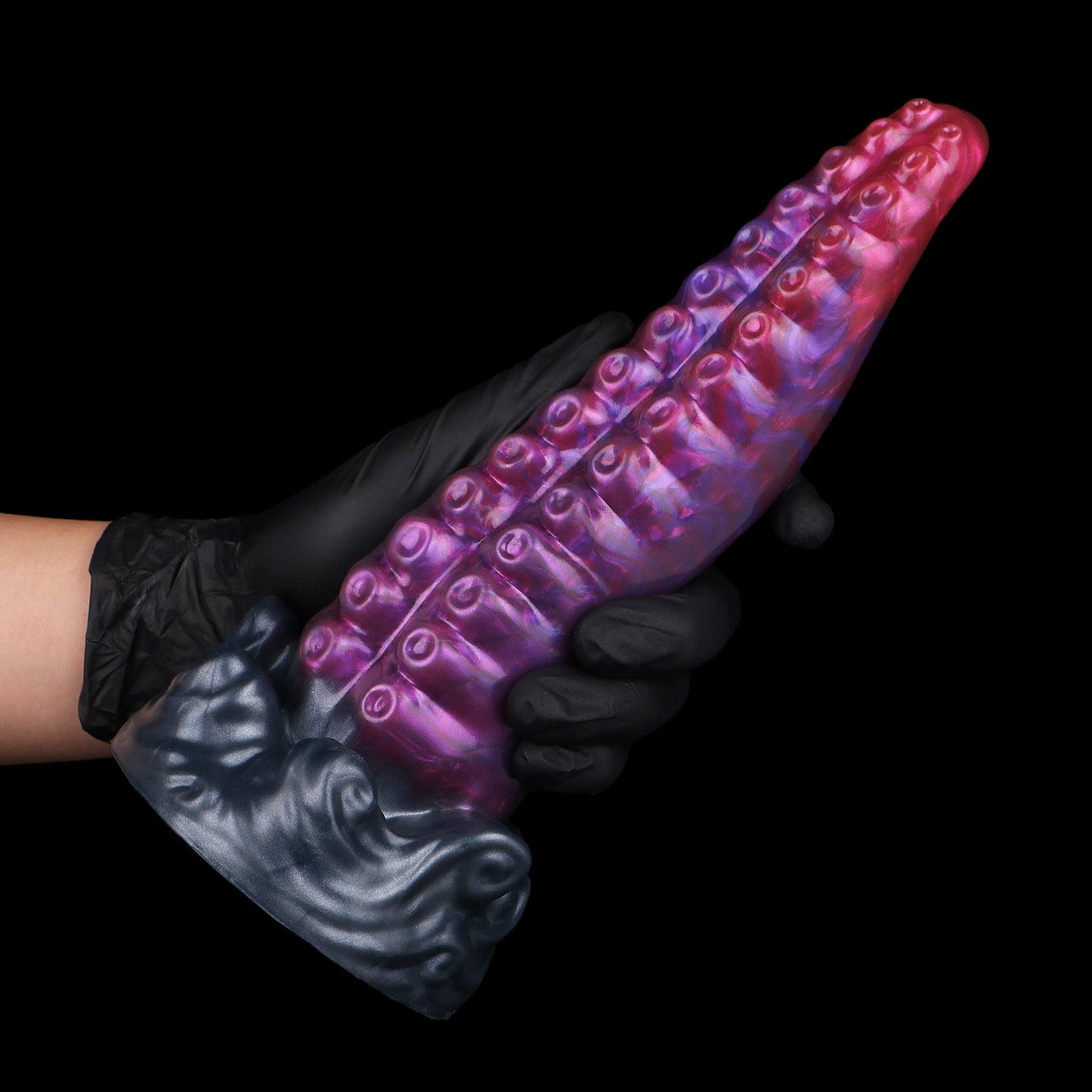 Tendrul the Tentacle dildo, Adrenaline colorway, held in a gloved hand showing the full length of the tentacle