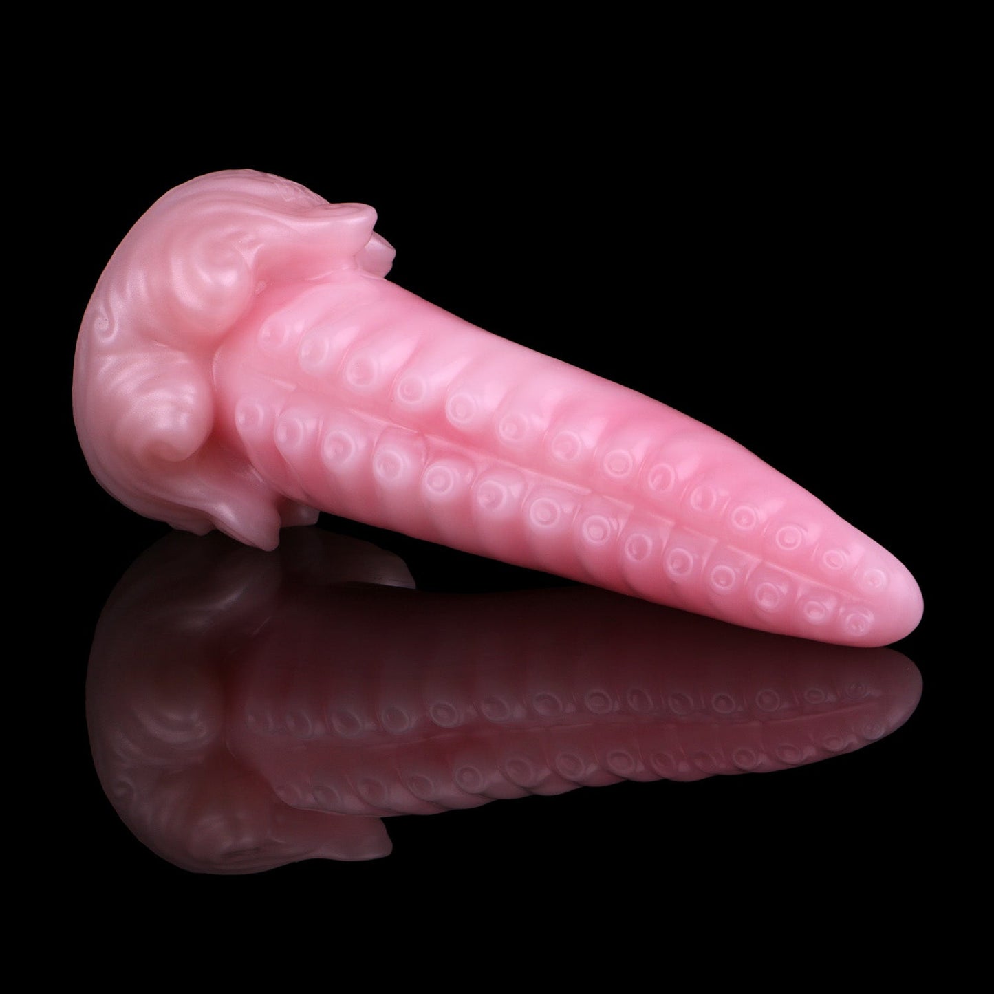 Tendrul the Tentacle dildo, Fairy Floss colorway, lying on its side in full profile showing the tapered tentacle and whirlpool-wave base