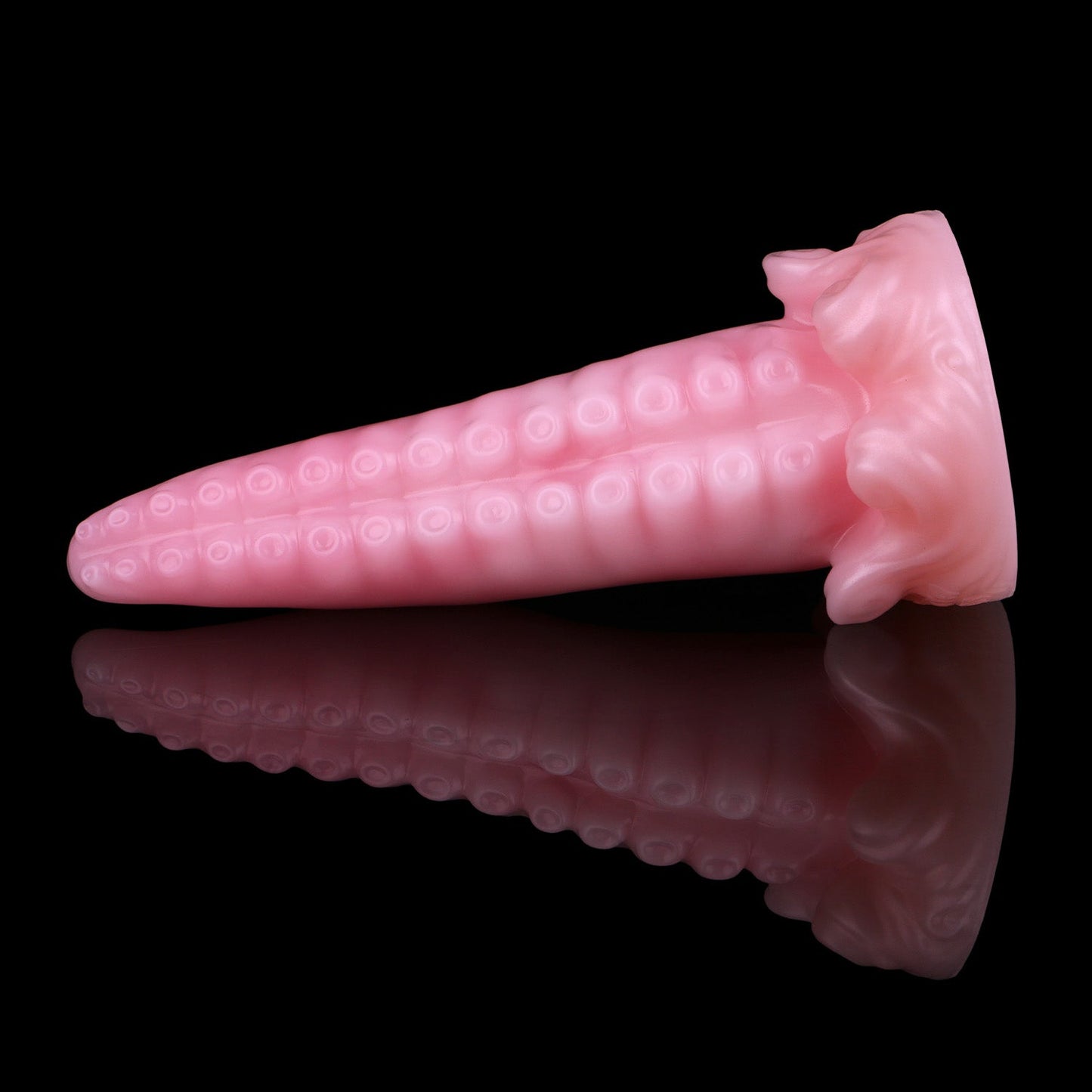 Tendrul the Tentacle dildo, Fairy Floss colorway, lying on its side with the whirlpool-wave base to the right