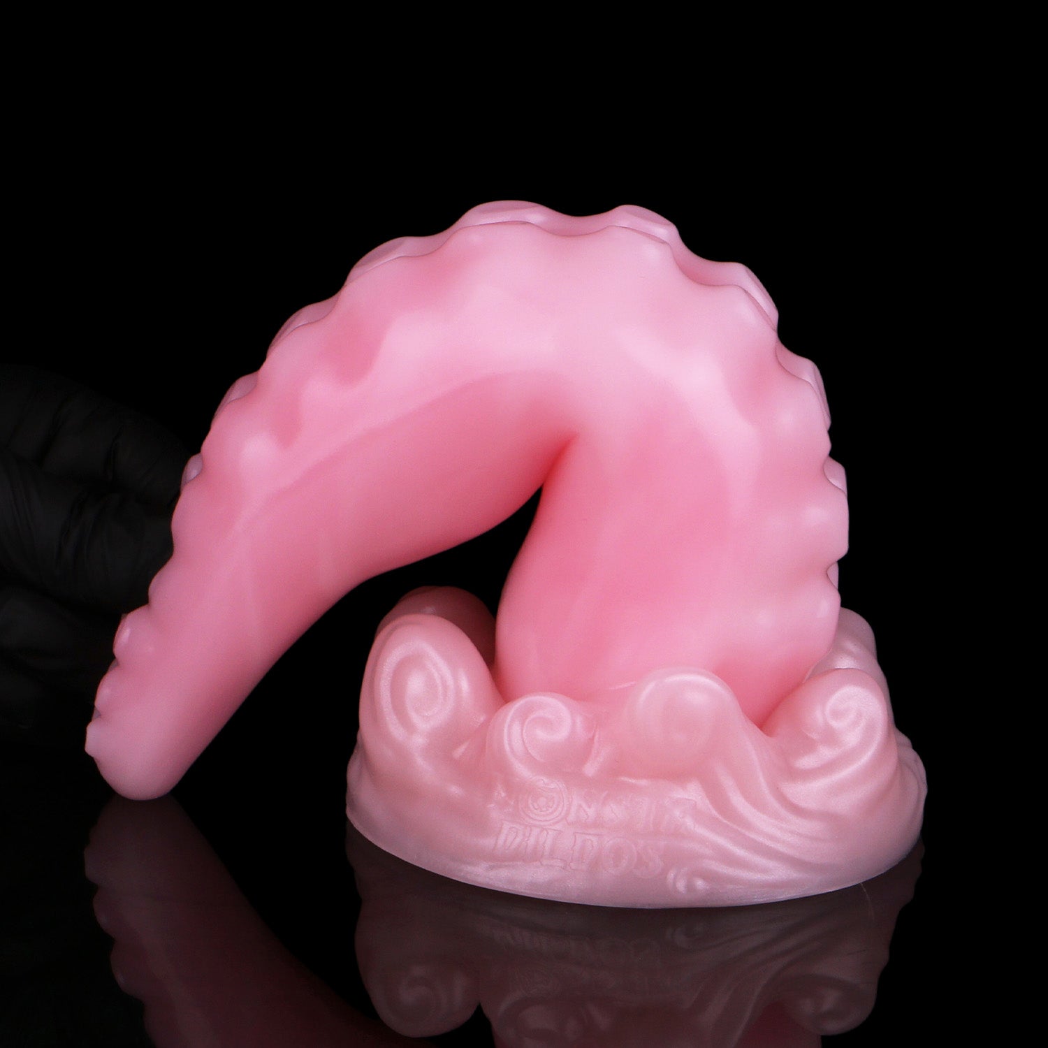 Tendrul the Tentacle dildo, Fairy Floss colorway, standing on its base with the tentacle curled over to show its flexibility