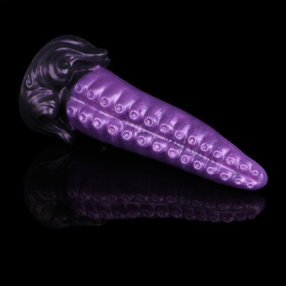 Tendrul the Tentacle dildo, Grape colorway, lying on its side in full profile showing the metallic grape tentacle and midnight-purple whirlpool base