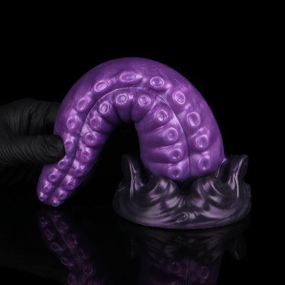 Tendrul the Tentacle dildo, Grape colorway, standing on its base with the tentacle curled over to show its flexibility