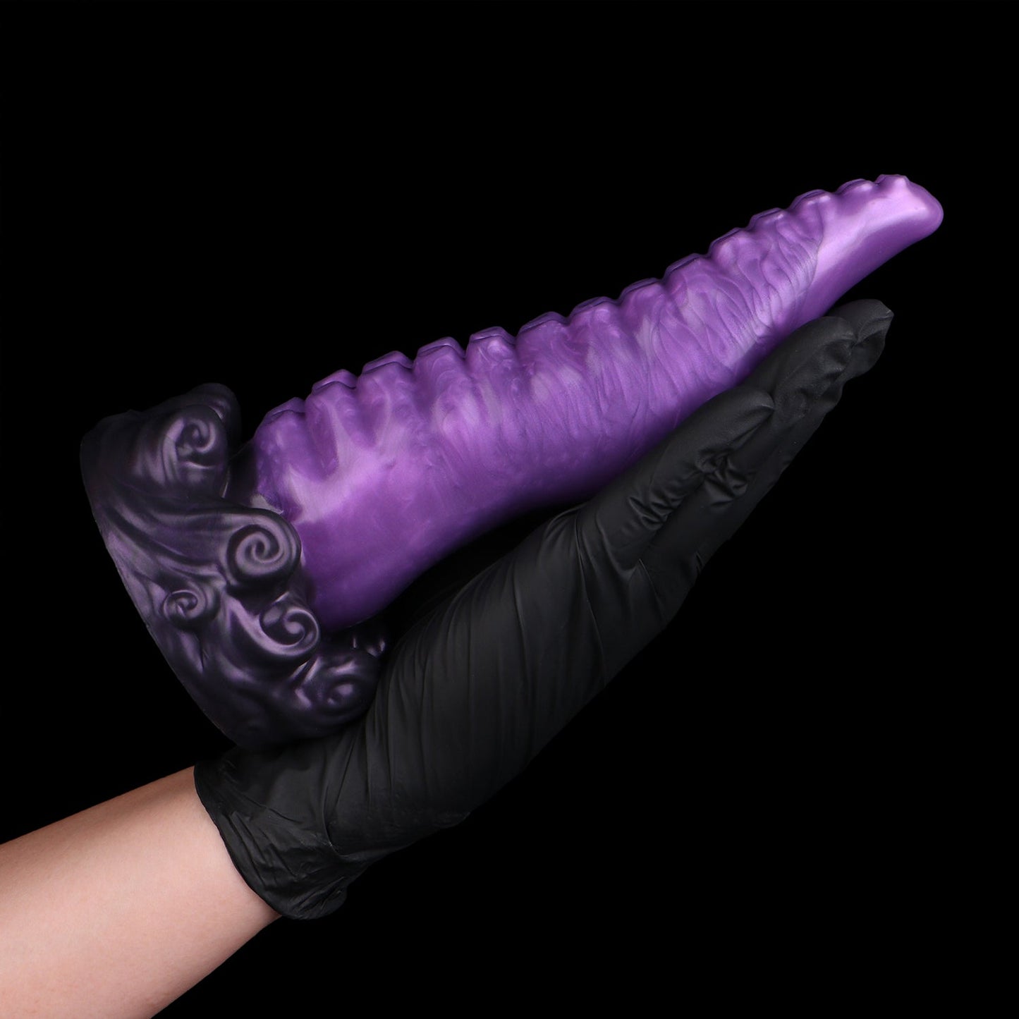 Tendrul the Tentacle dildo, Grape colorway, held in a gloved hand showing the full length of the tentacle