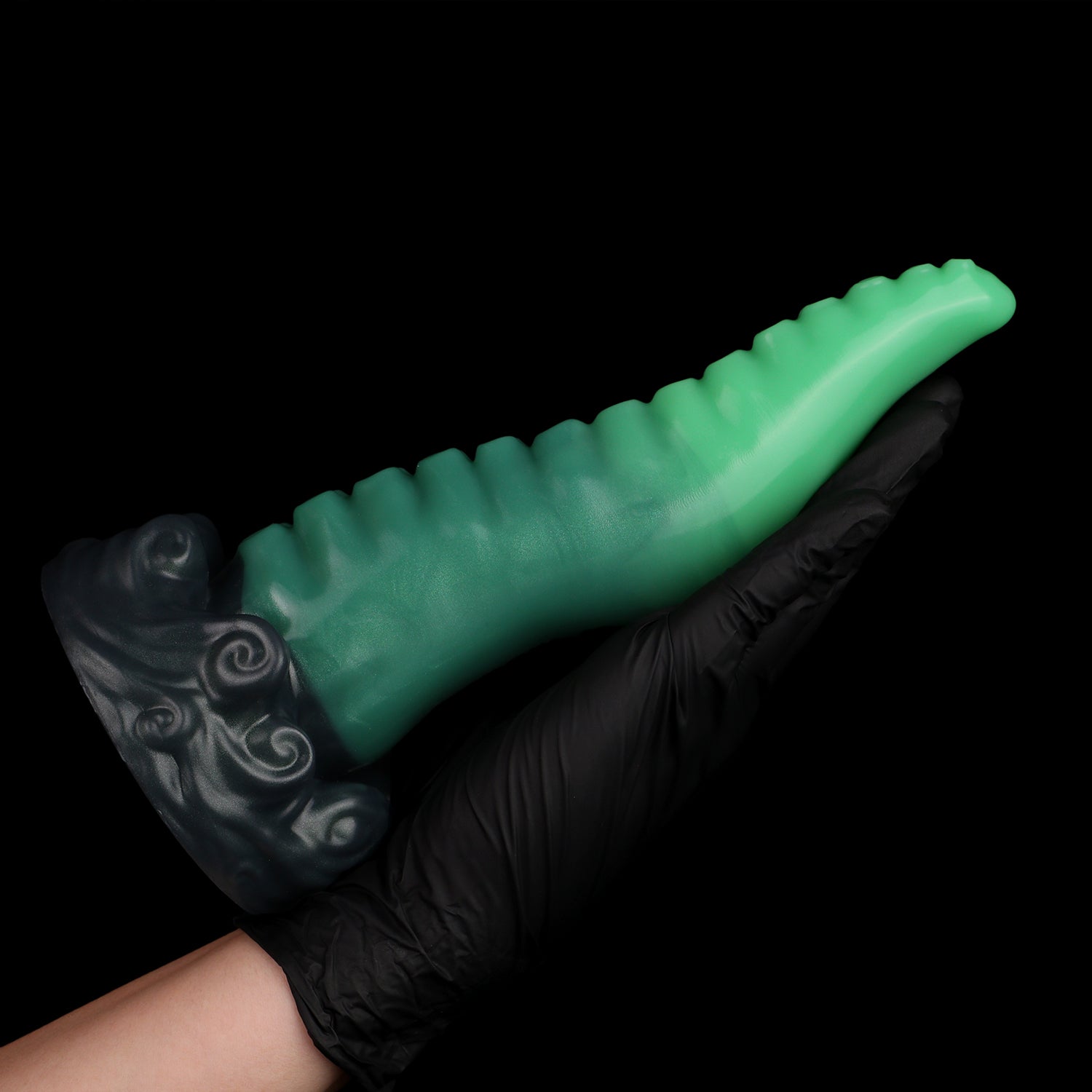 Tendrul the Tentacle dildo, Ogre colorway, held in a gloved hand showing the full length of the tentacle