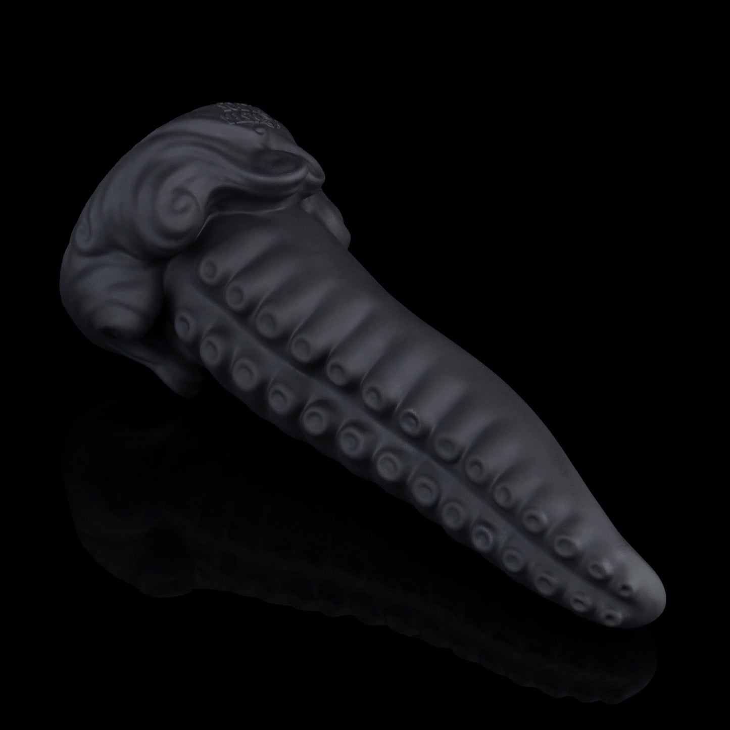 Tendrul the Tentacle dildo, Shadow colorway, lying on its side in full profile showing the tapered tentacle and whirlpool-wave base