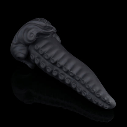 Tendrul the Tentacle dildo, Shadow colorway, lying on its side in full profile showing the tapered tentacle and whirlpool-wave base