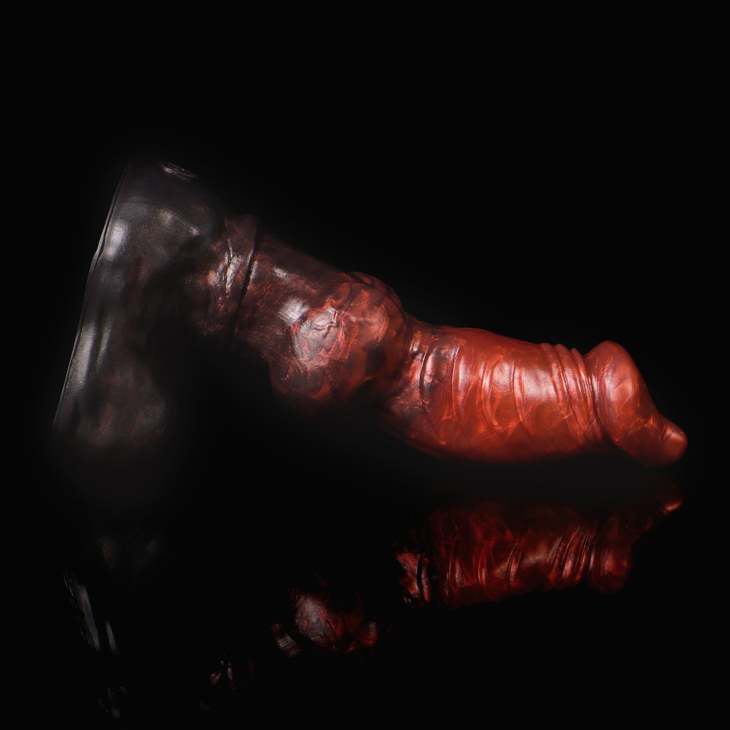 Vulpes the Nightfox dildo, Lava colorway, lying on its side in low-key lighting showing the ribbed shaft